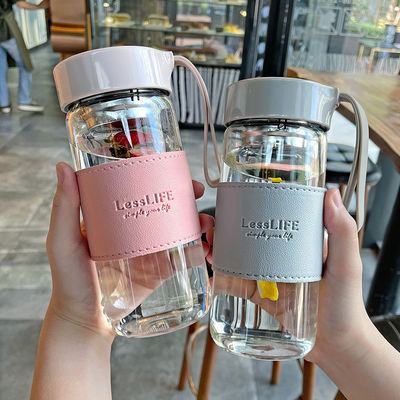 Botella de agua de vidrio de borosilicato personalizada de 480 ml con manga de cuero e infusor de té