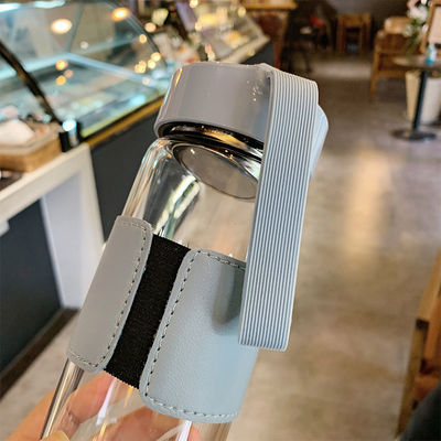 Botella de agua de vidrio de borosilicato personalizada de 480 ml con manga de cuero e infusor de té